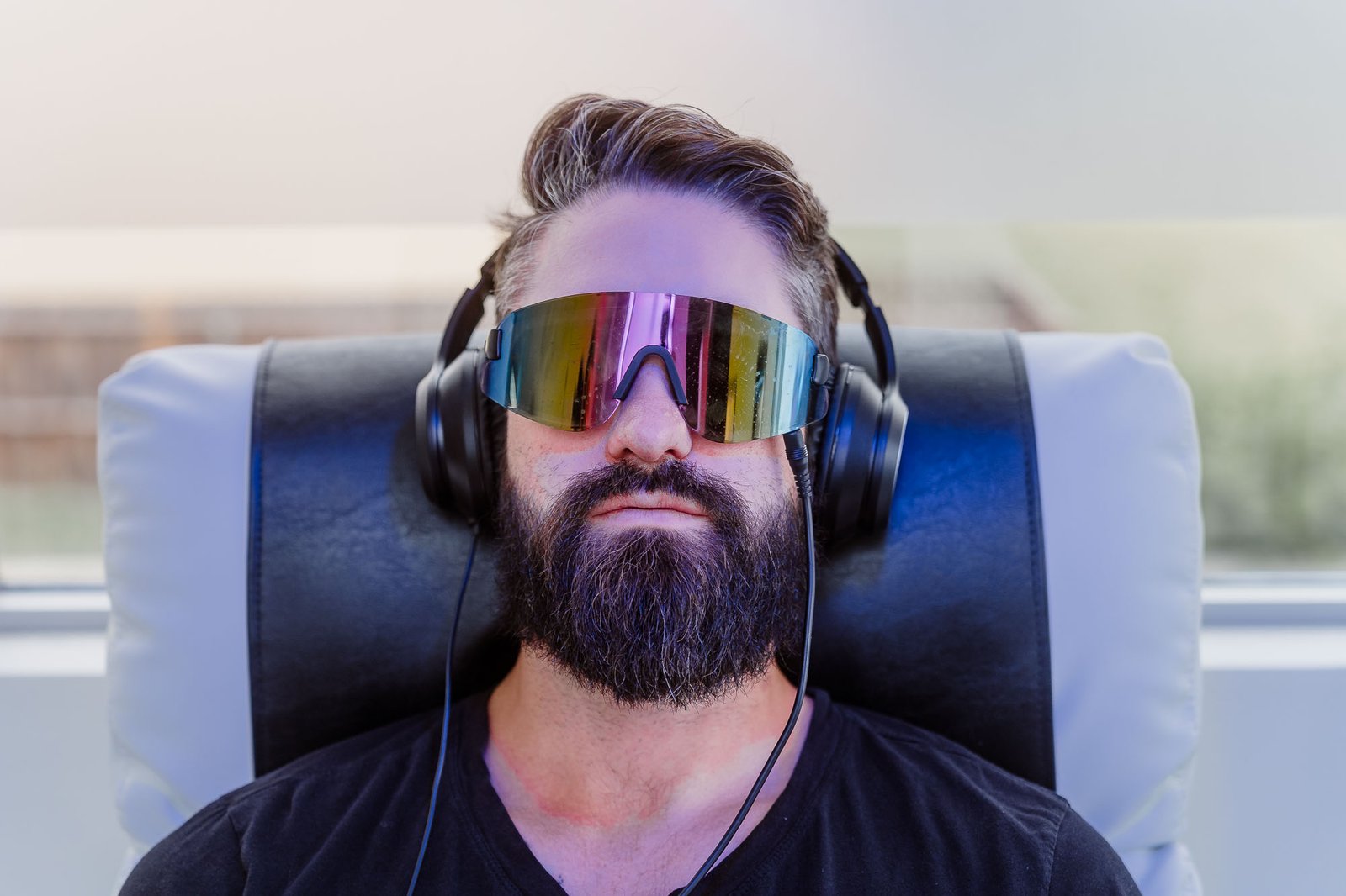 Persona relajándose con gafas de luz y auriculares de terapia de ondas cerebrales