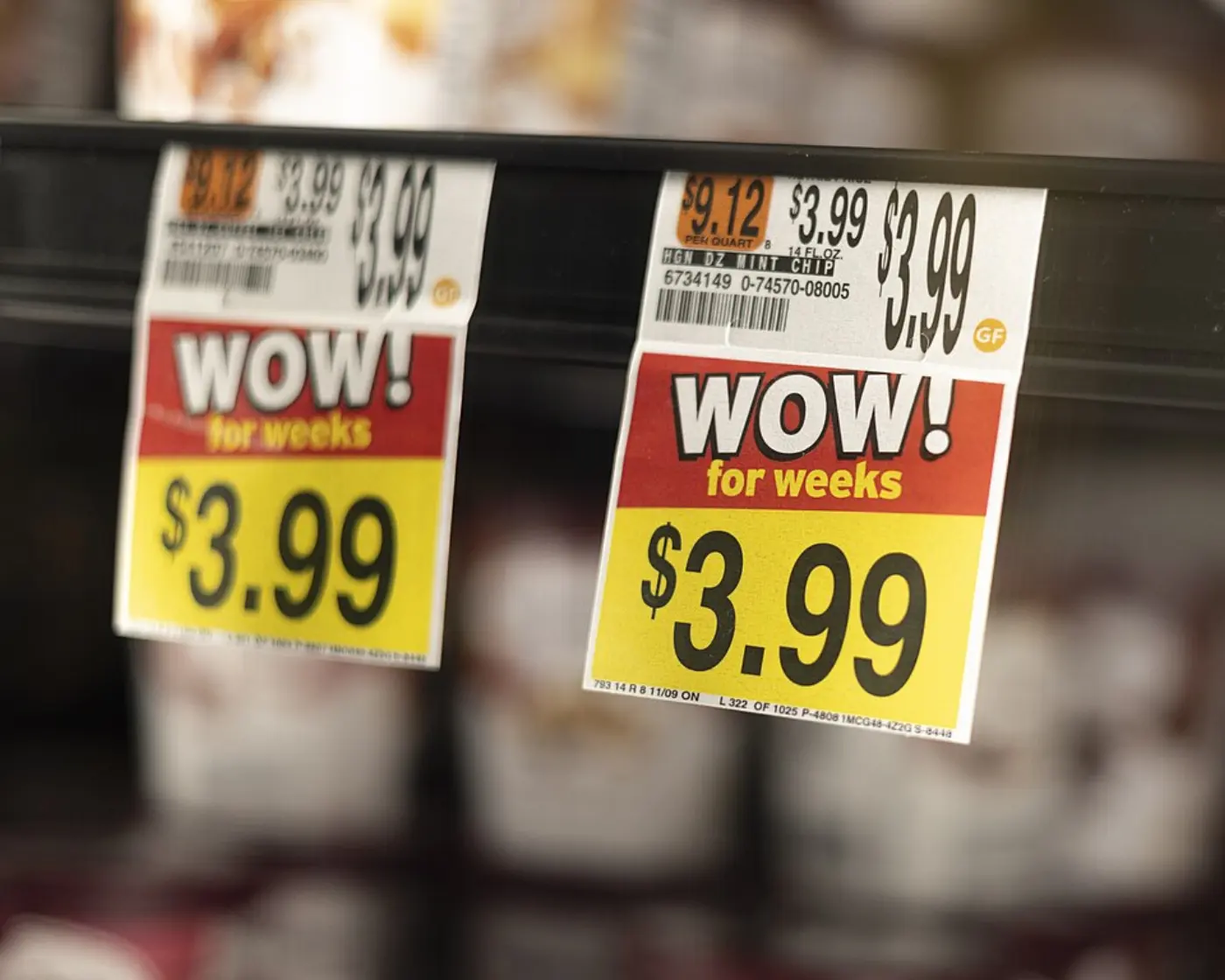 Two bright red and yellow shelf price tags reading WOW for weeks, $3.99, in a grocery store