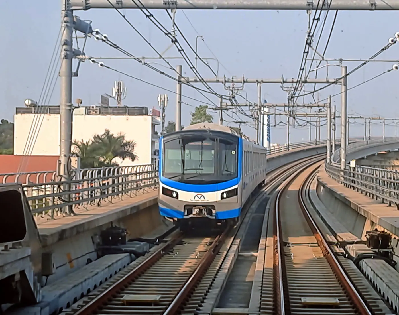 Đoàn tàu Metro số 1 màu trắng xanh chạy trên đường ray trên cao ở TP.HCM