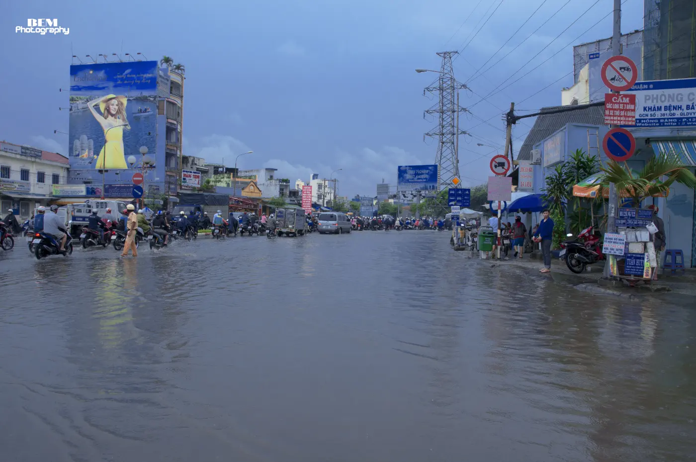 Một con đường lớn ở Sài Gòn ngập nước, xe máy dừng chờ ở mép nước