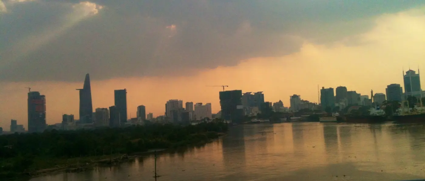 The Ho Chi Minh City skyline at sunset seen across the Saigon River