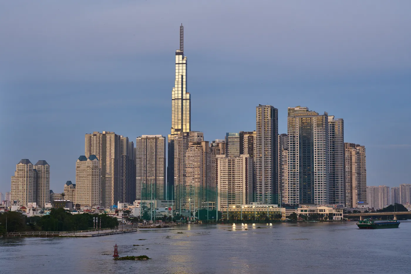 Saigon River in the evening with high-rise towers and Landmark 81 on the far bank