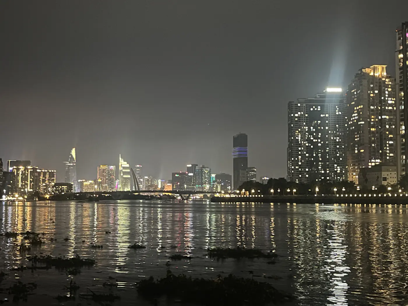 Les gratte-ciel illuminés du centre de Hô Chi Minh-Ville la nuit, vus depuis Thủ Đức, de l'autre côté de la rivière