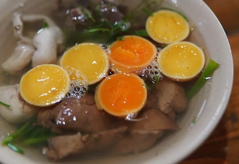 Cuenco con huevos tiernos de gallina de color naranja, menudillos y cebolleta